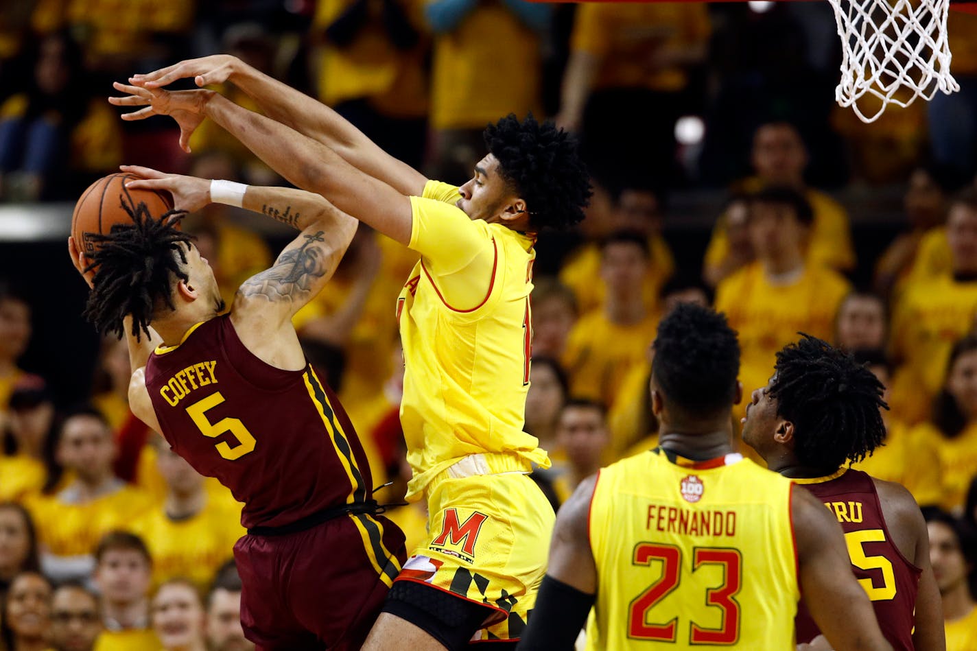 Minnesota guard Amir Coffey, left, attempts to shoot as he is pressured by Maryland forward Ricky Lindo Jr. in the second half of an NCAA college basketball game, Friday, March 8, 2019, in College Park, Md. (AP Photo/Patrick Semansky)