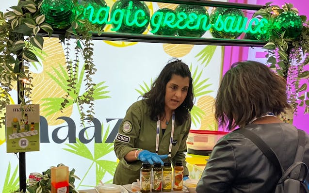 Fatima Sajady, the inspiration for St. Paul-based Maazah sauces and dips, talks to an attendee at Expo West in Anaheim, Calif., in March. As Maazah an