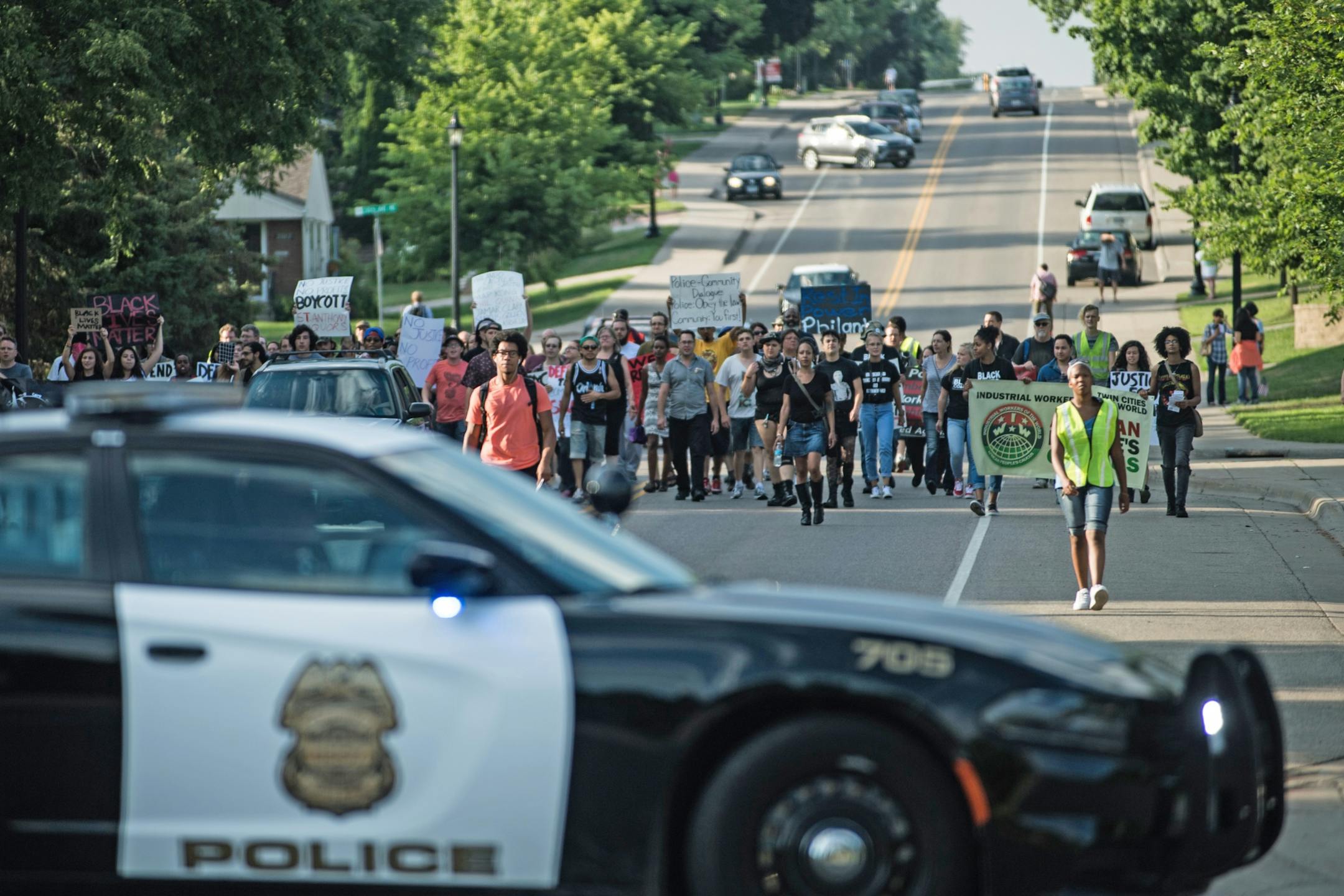 Demonstrators marched down Silver Lake Road in St. Anthony Village on their way to protest outside of St. Anthony Village Wine and Spirits, a municipal liquor store that contributes to the city's police budget.