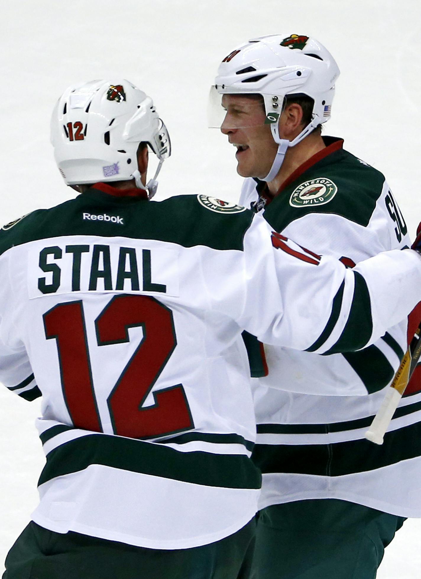 CORRECTS THAT SUTER HAD AN ASSIST ON THE GOAL, RATHER THAN SCORED THE GOAL - Minnesota Wild's Ryan Suter, right, celebrates his assist on a goal by Charlie Coyle with Eric Staal (12) during the first period of an NHL hockey game against the Pittsburgh Penguins in Pittsburgh, Thursday, Nov. 10, 2016. (AP Photo/Gene J. Puskar)