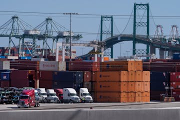 Trucks lined up next to containers at the Port of Los Angeles in San Pedro, Calif.