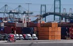 Trucks lined up next to containers at the Port of Los Angeles in San Pedro, Calif.