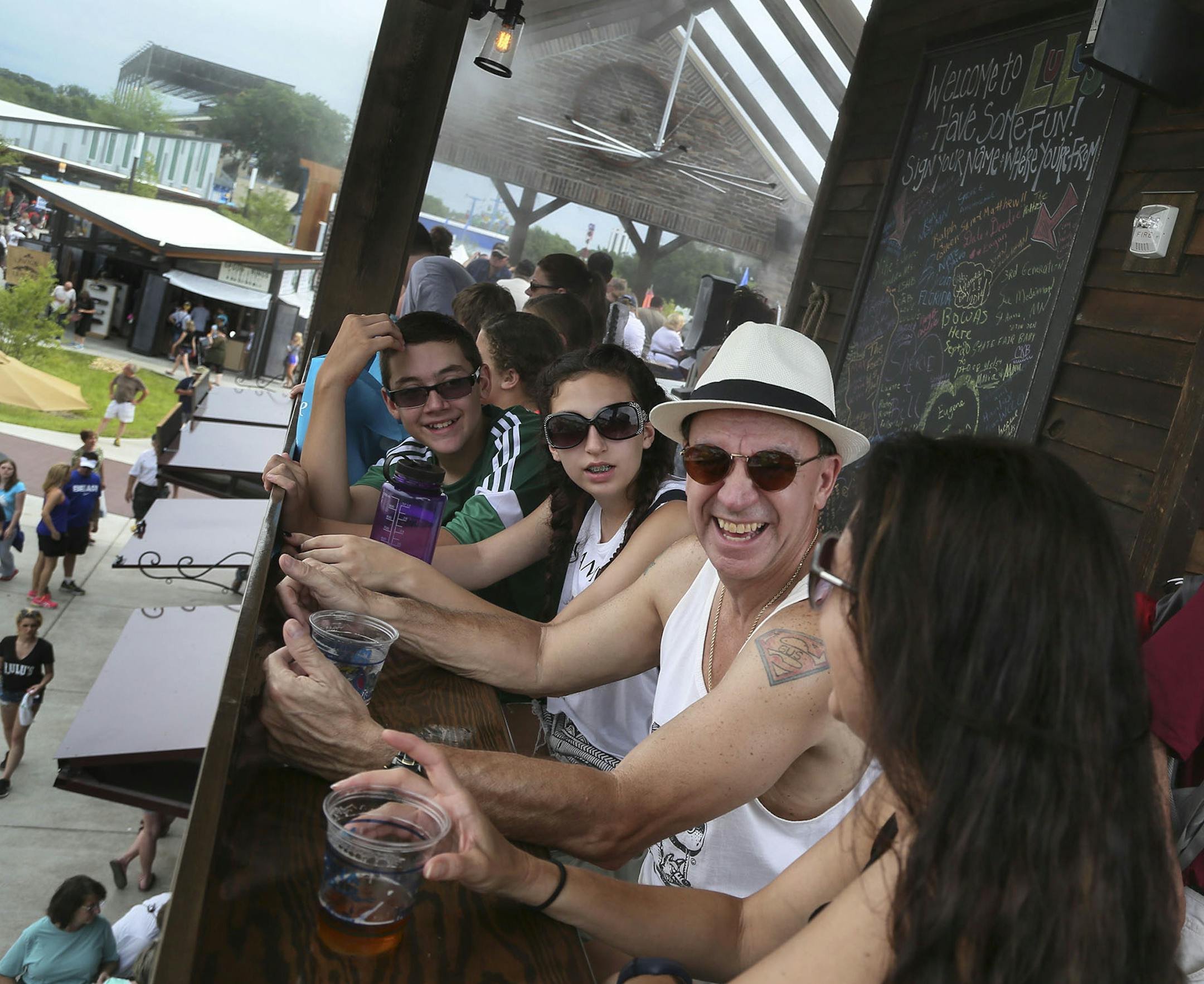 Among the new food establishments available to visitors to the Minnesota State Fair is Lulu's Public House and seen Thursday, Aug. 21, 2014 in Falcon Heights, MN. Lulu's features a second story with misting machines to keep customers cool, like John Martinez, second from front, with his children Henry Martinez, left to right, Sophie Martinez and Angie Sokol.] (DAVID JOLES/STARTRIBUNE) djoles@startribune Annual survey of new foods at the MN State Fair.**John Martinez, Henry Martinez, Sophie Marti