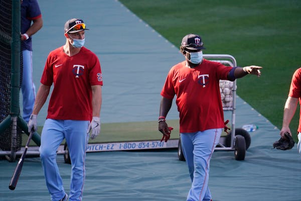 Twins players wear masks during batting practice Friday. Saturday's game was called off.