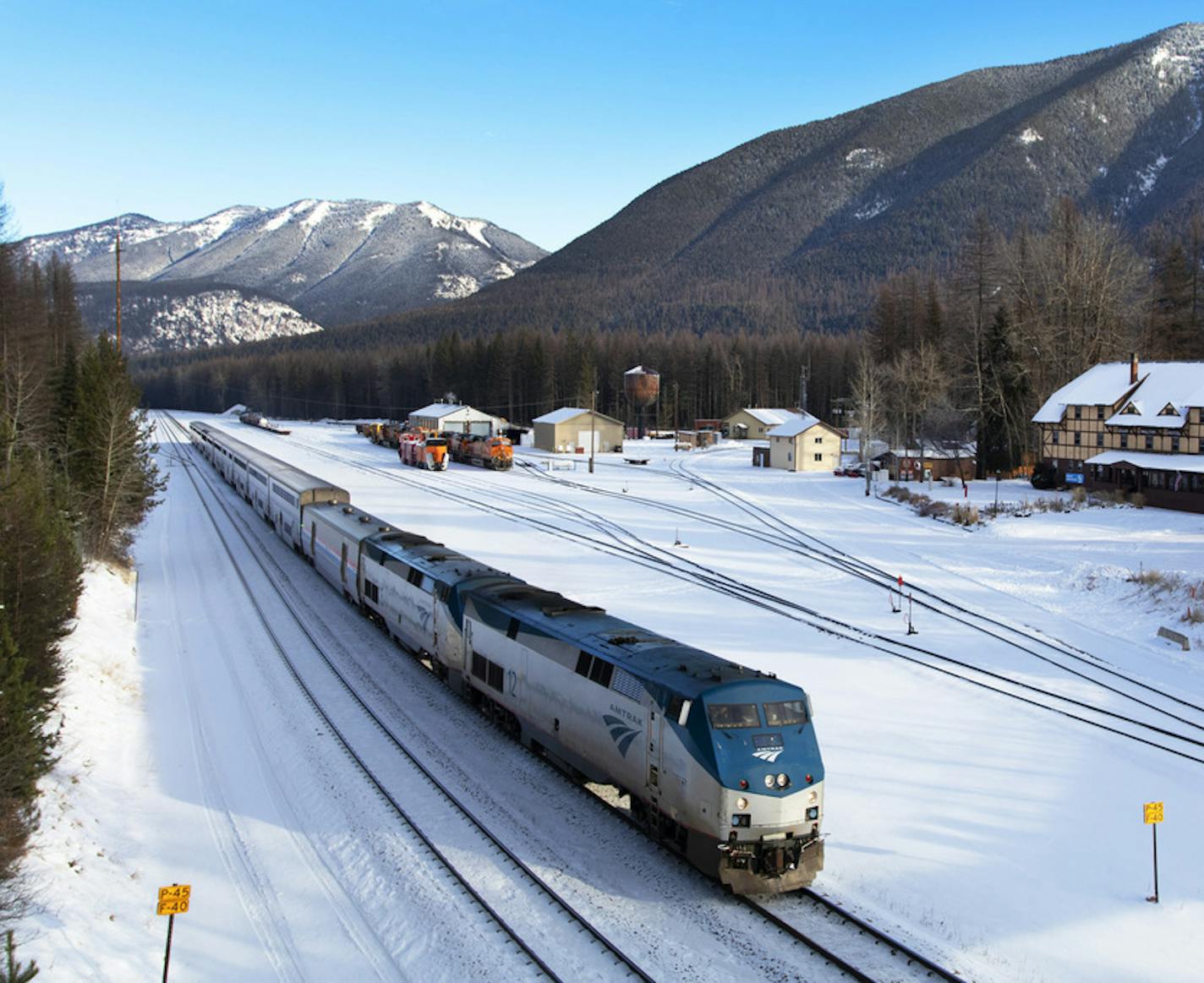 File - In this Dec. 1, 2019 file photo, an Amtrak train passes the Izaak Walton Inn in Essex, Montana. The hotel that was built 80 years ago in anticipation of an entrance that was never constructed at the southern border of Glacier National Park is thriving as a popular destination for hikers and cross-country skiers (Justin Franz/The Flathead Beacon via AP, File)