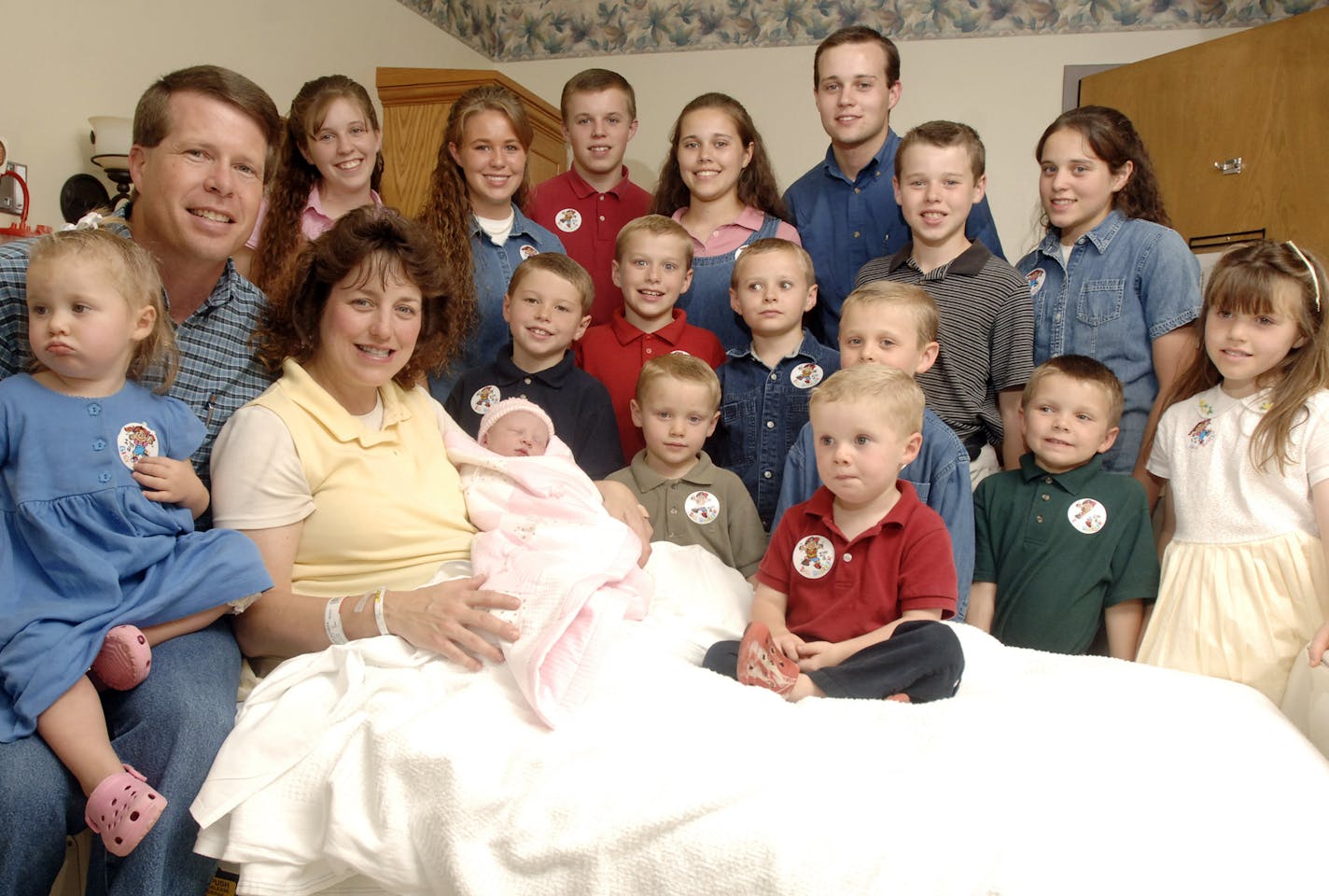 FILE - In this Aug. 2, 2007 file photo, Michelle Duggar, left, is surrounded by her children and husband Jim Bob, second from left, after the birth of her 17th child in Rogers, Ark. Arkansas couple Jim Bob and Michelle Duggar announced Tuesday, Nov. 8, 2011 that they are expecting their 20th child in April. (AP Photo/ Beth Hall, File)