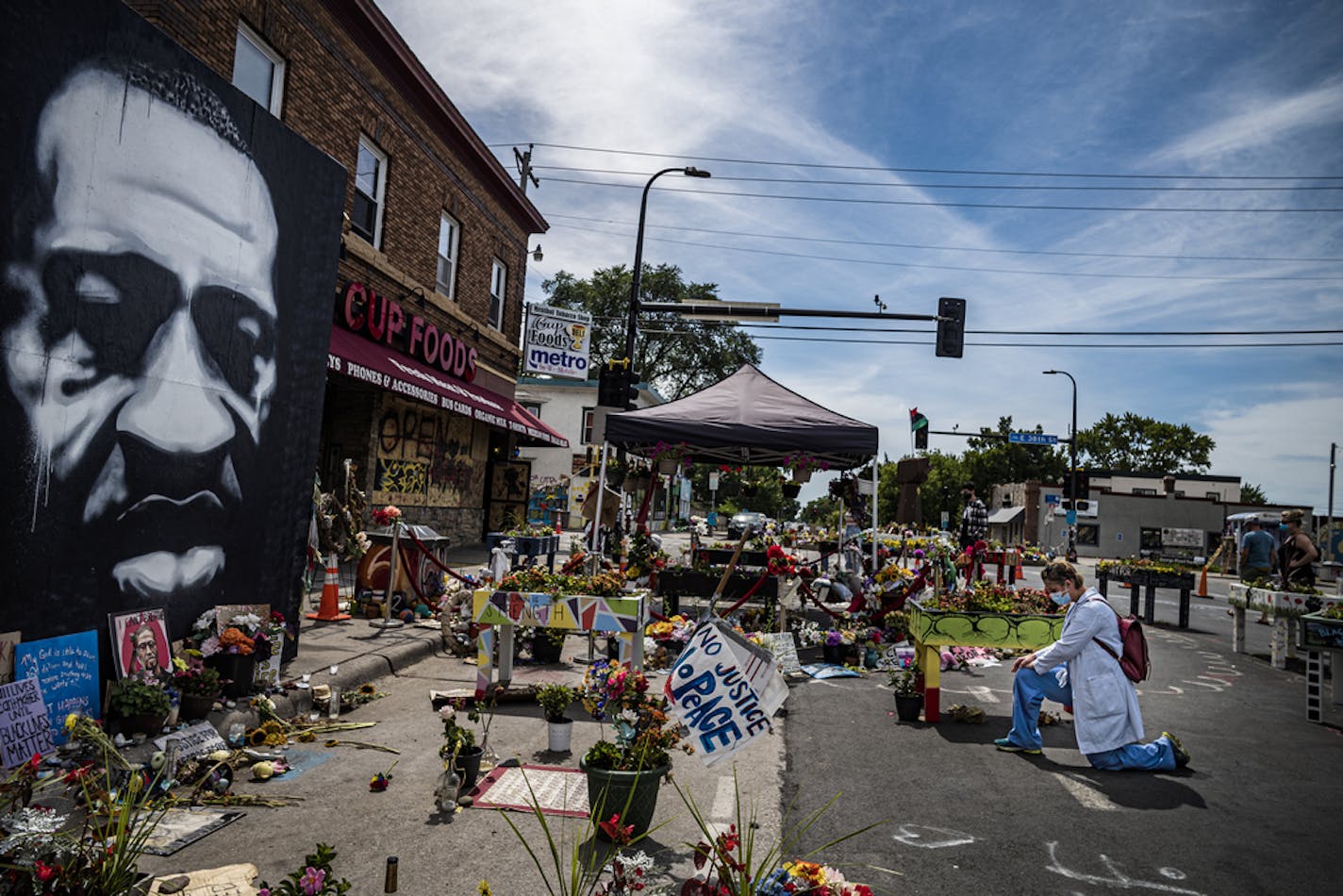 Dr. Megan Jennings took a knee at the George Floyd memorial. "I have felt distraught by all of this," she said. The incident has made her and colleagues to look for evidence of systemic racism in her group practice. Activists have demanded that the intersection of 38th and Chicago remain closed to traffic as the city of Minneapolis seeks to reopen it.] Street scene from George Floyd memorial site. RICHARD TSONG-TAATARII ¥ richard.tsong-taatarii@startribune.com