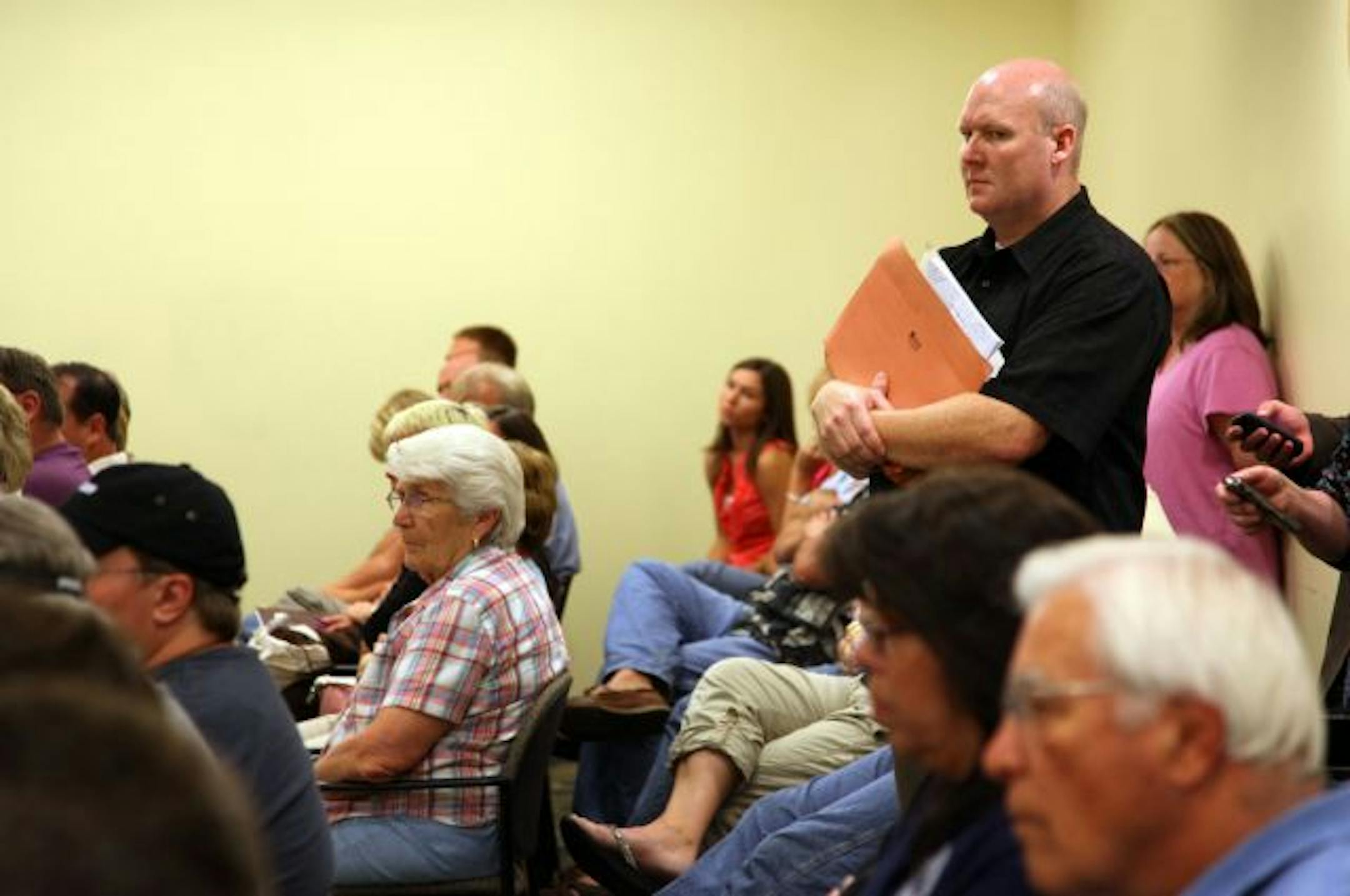 Drew Anderson stood in the back of the City Council Chambers Monday night during a hearing over whether or not he should lose his job over 'misconduct.'