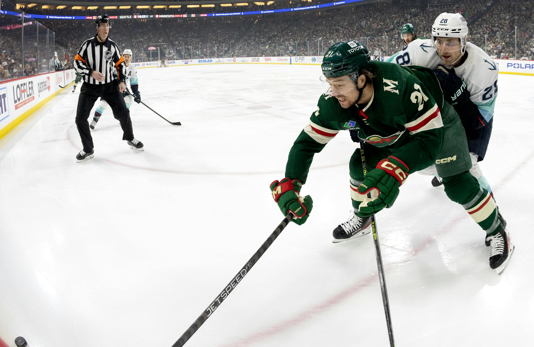 Brandon Duhaime (21) of the Minnesota Wild and Carson Soucy (28) of the Seattle Wild battle for the puck in the first period.