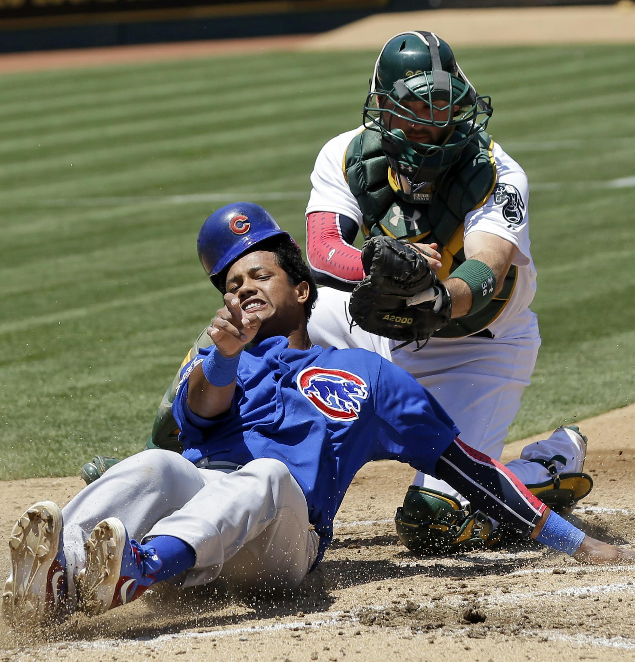 Chicago Cubs' Starlin Castro, left, is tagged out at the plate by Oakland Athletics catcher Derek Norris as he tried to score from second base on a single by Alfonso Soriano during the fourth inning of an MLB baseball game on Thursday, July 4, 2013 in Oakland, Calif. (AP Photo/Marcio Jose Sanchez)