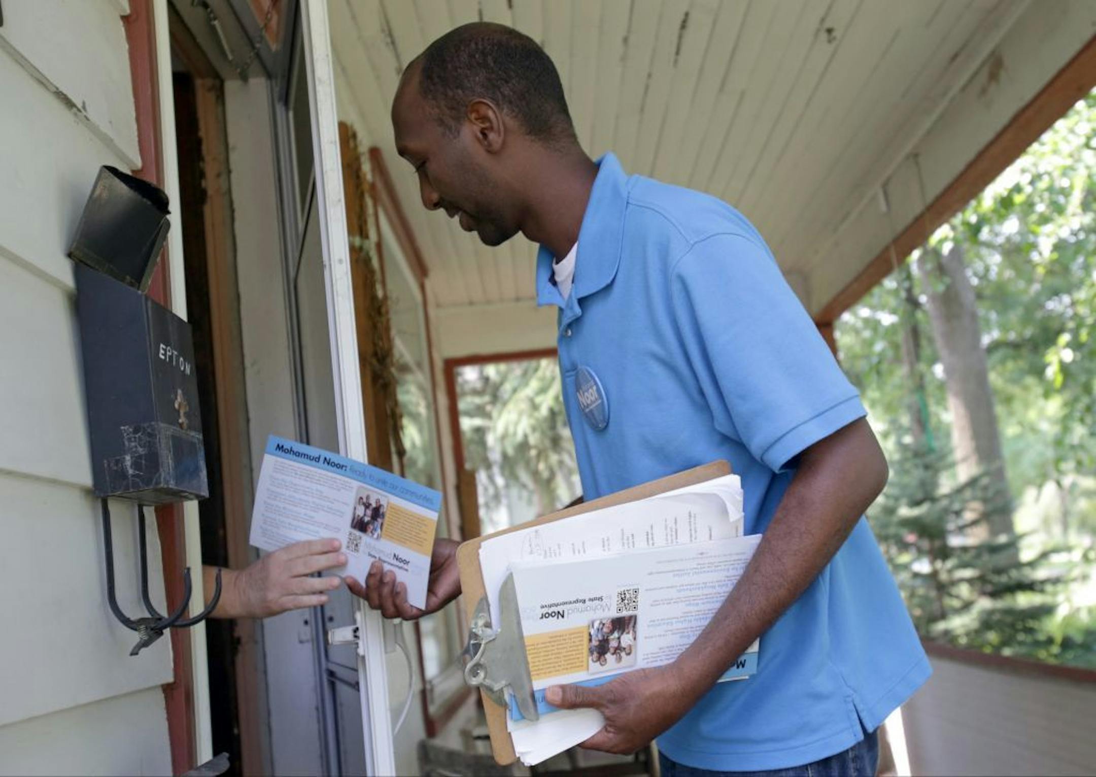 In this July 17, 2014 photo, Mohamud Noor hands out his campaign literature in the Seward neighborhood of Minneapolis. A Noor victory would presumably set him on course to be the highest-ranking Somali-American elected official in the country. He�s trying to bump one of the Legislature�s longest-ever serving House members in Phyllis Kahn.