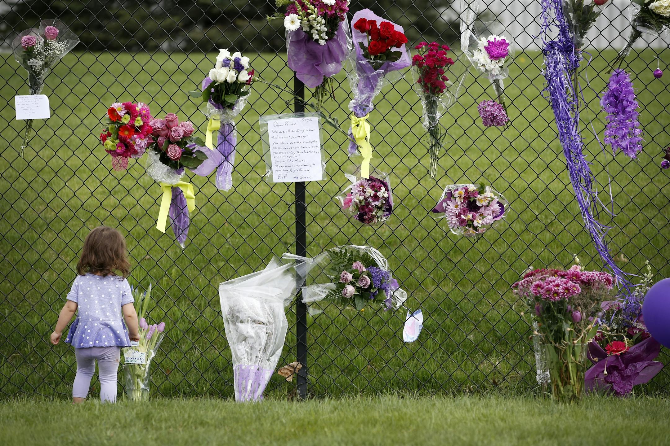 Kayleen Johnson, 1, of Cambridge, MN stood near a memorial at Paisley Park Studios in Chanhassen, MN. Musician Prince was found dead at the site on Thursday morning.
