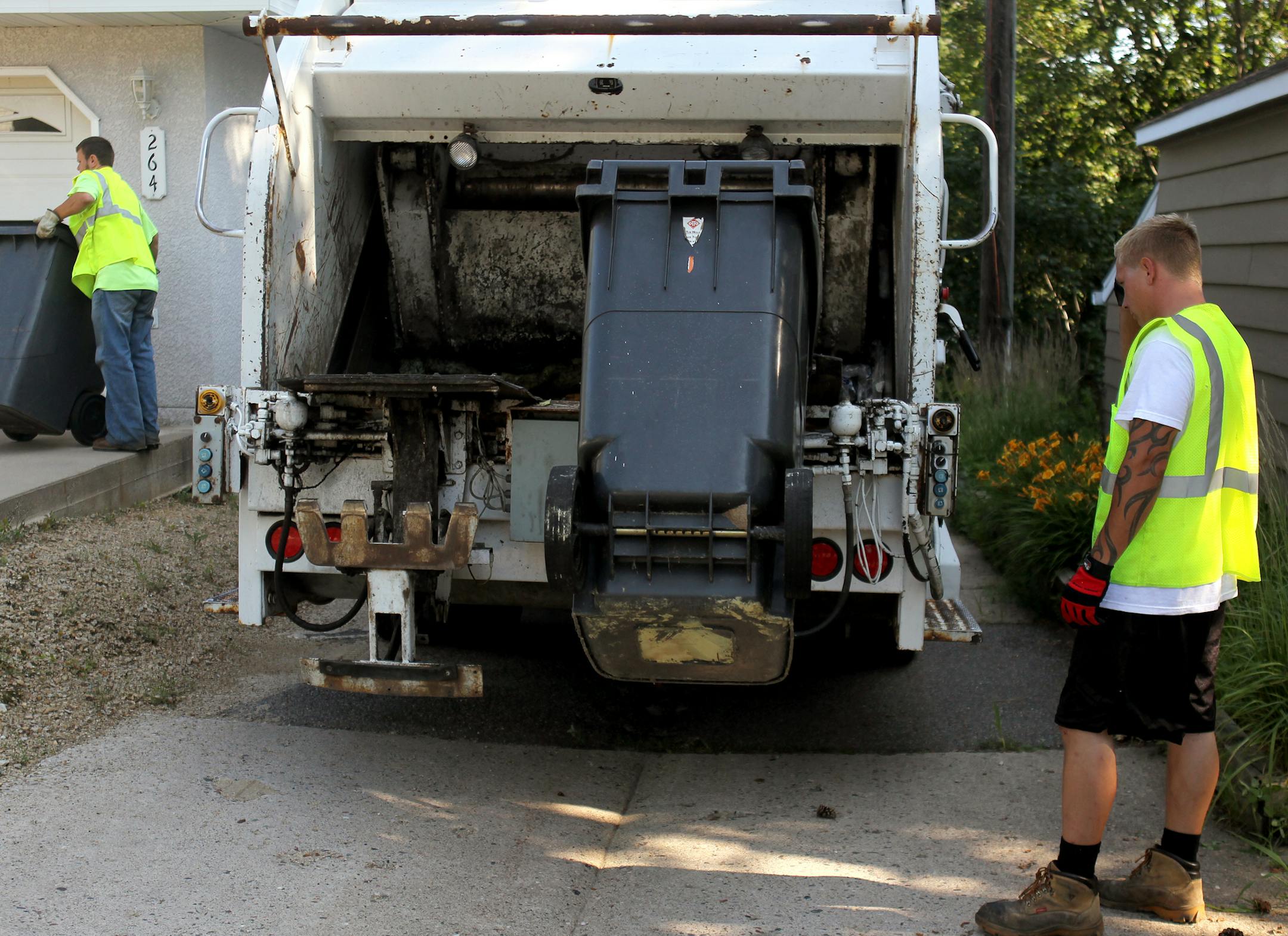 Josh Hall, left, and Alan Wright, of Charlie Hall Disposal Inc., spent their day collecting trash on the same day Minneapolis opened bidding for a multimillion dollar trash contract.