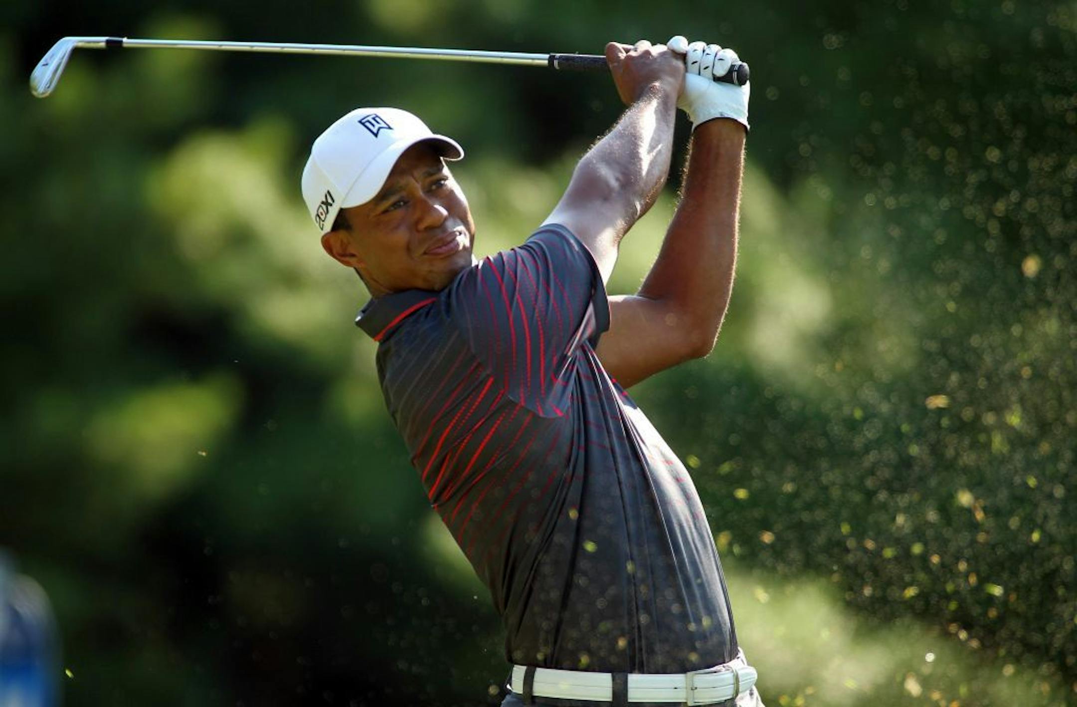 Tiger Woods hits off the 11th tee during the first round of the Deutsche Bank Championship golf tournament at TPC Boston in Norton, Mass., Friday, Aug. 31, 2012.