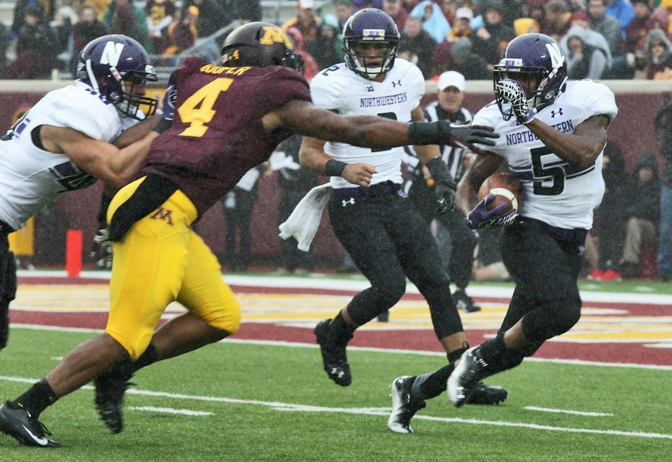 Northwestern running back Venric Mark picked up first half rushing yardage beating Minnesota defender Keanon Cooper.