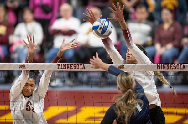 The Gophers’ Carter Booth, left, going up for a block against Illinois earlier this month, had eight kills and five blocks in a 3-0 win over Michiga