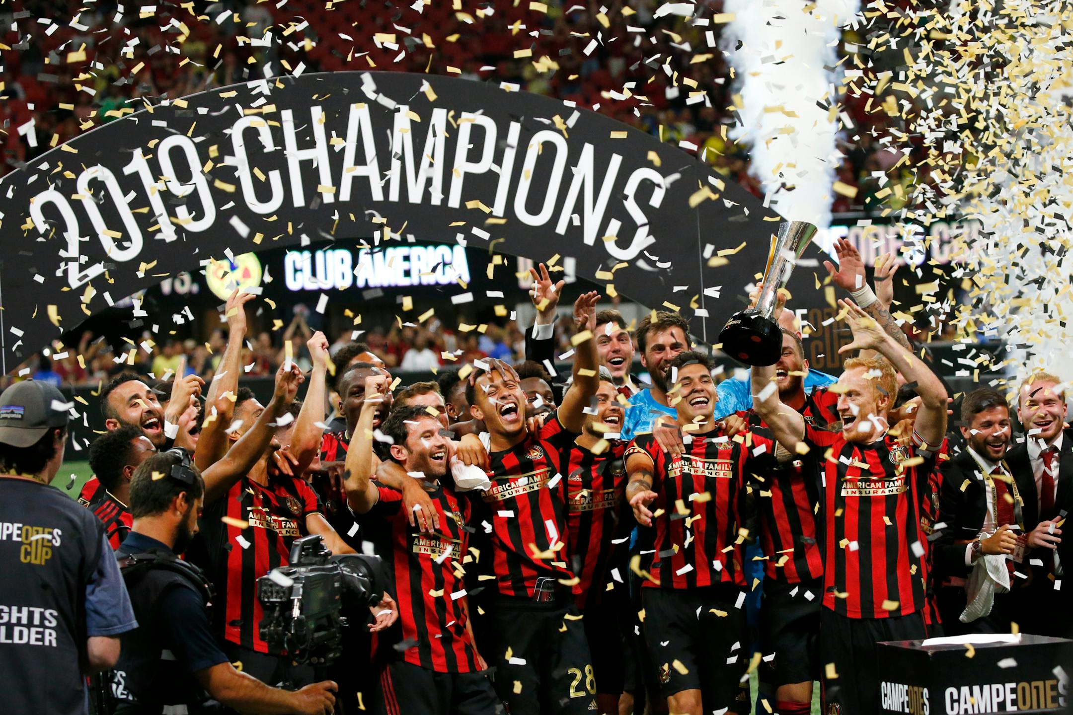 Atlanta United team members celebrate with the trophy after defeating Club America 3-2 in the Campeones Cup soccer final Wednesday, Aug. 14, 2019, in Atlanta. (AP Photo/John Bazemore)