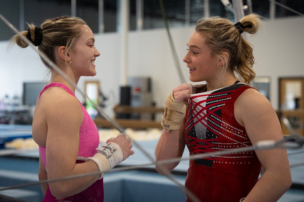 Lexi Zeiss chats with best friend Elle Mueller during practice at Twin City Twisters in Champlin, Minn., on March 29.
