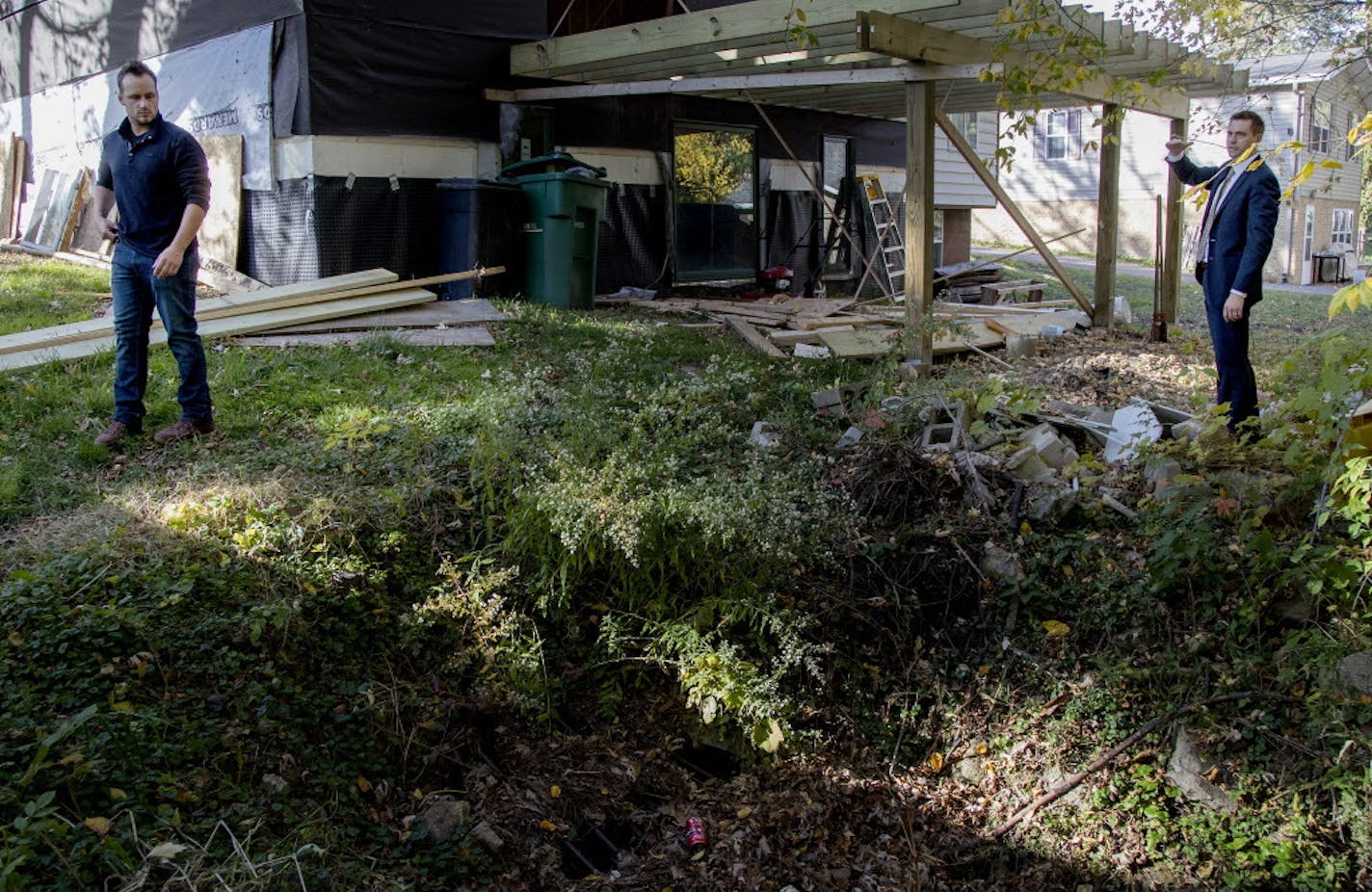 Josh Hague and his attorney Andrew Pieper stood in his backyard, which has had flooding.