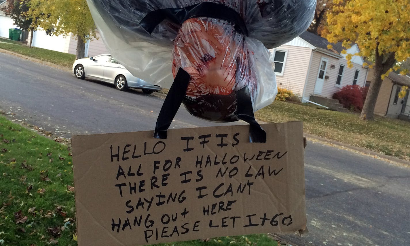 The realistic looking 'bodies' are wrapped in plastic and tape and hang from their feet in front of the St. Louis Park home.