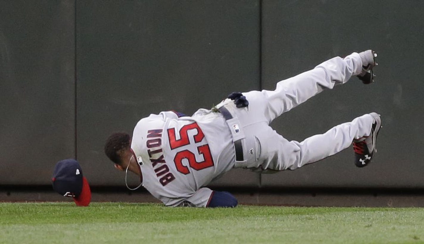 Minnesota Twins center fielder Byron Buxton lands after making a leaping catch of a line drive hit by Seattle Mariners' Robinson Cano during the fifth inning of a baseball game, Thursday, June 8, 2017, in Seattle.