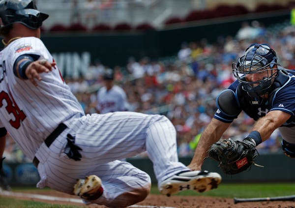 Oswaldo Arcia slid safely past Tampa Bay catcher Curt Casali in the second inning, scoring the Twins' first run Sunday.