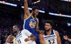 Warriors forward Andrew Wiggins reacts after dunking against the Timberwolves' Naz Reid and Karl-Anthony Towns during the second half Wednesday.