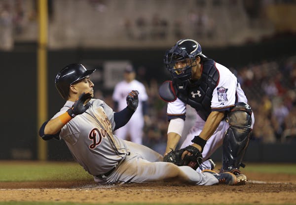 The Tigers' Jose Iglesias was tagged out at home by Twins catcher Kurt Suzuki when trying to score on a pop out by Detroit designated hitter Victor Ma