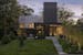 The charcoal-hued chimney and stone wall make a dramatic statement in the front entry of a new Wayzata home was designed by Peterssen/Keller Architect