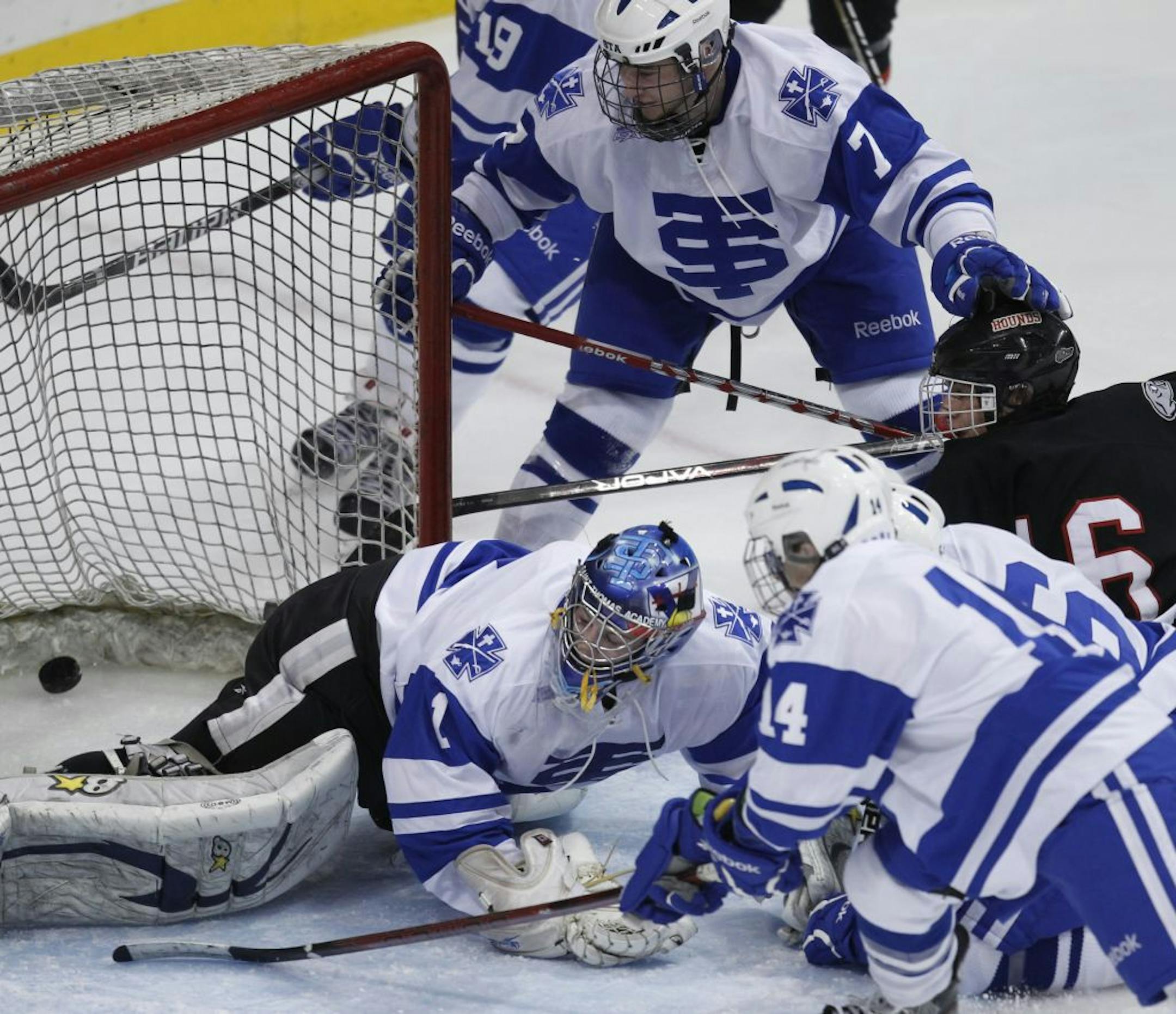 Duluth East's Bryan Lundgren scored despite the efforts of St. Thomas Academy goalie Dave Zevnik.