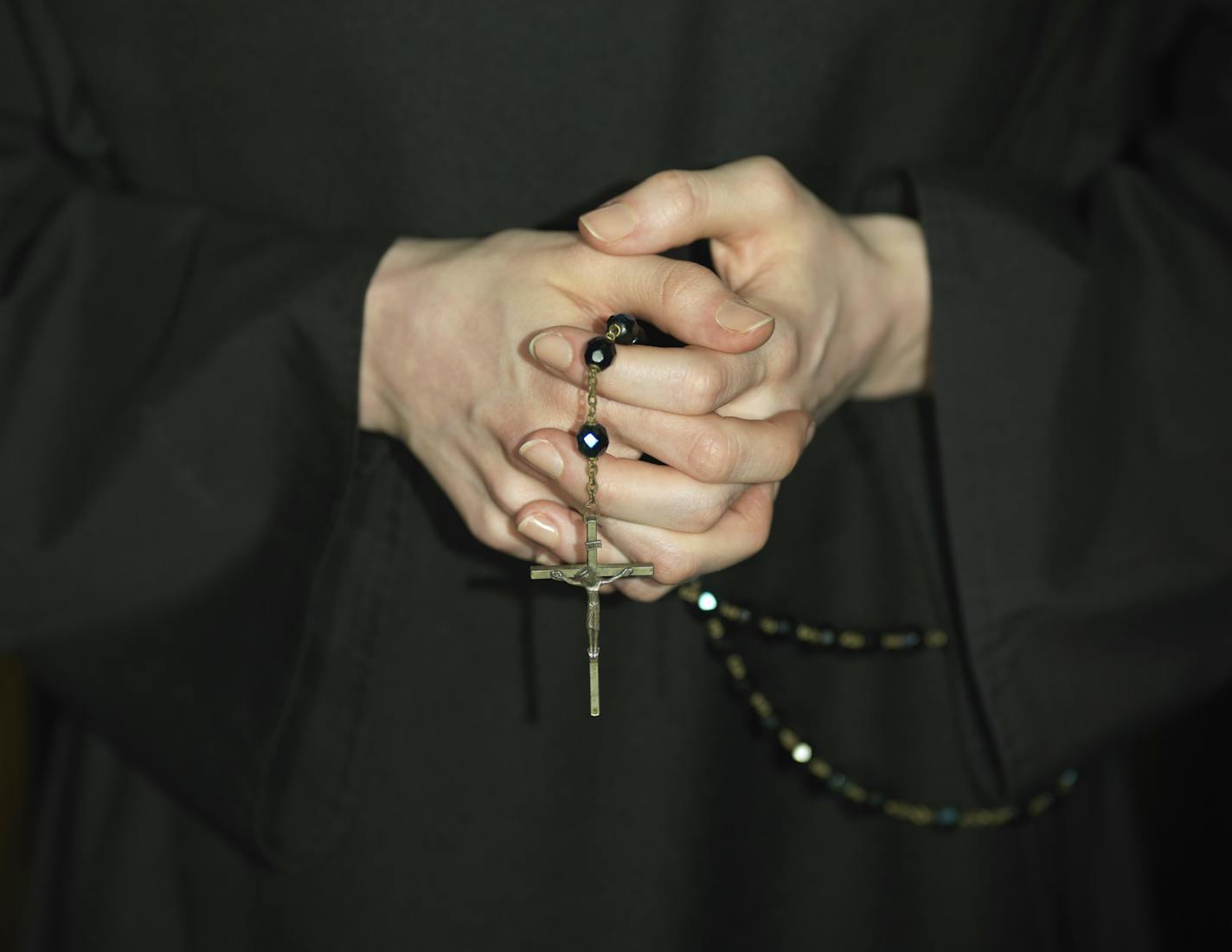 Close-up on a a nun's hands holding a rosary