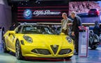 Men look at an Alfa Romeo 4C Spider during the media day of the 94rd European Motor Show in Brussels on Tuesday, Jan. 12, 2016.