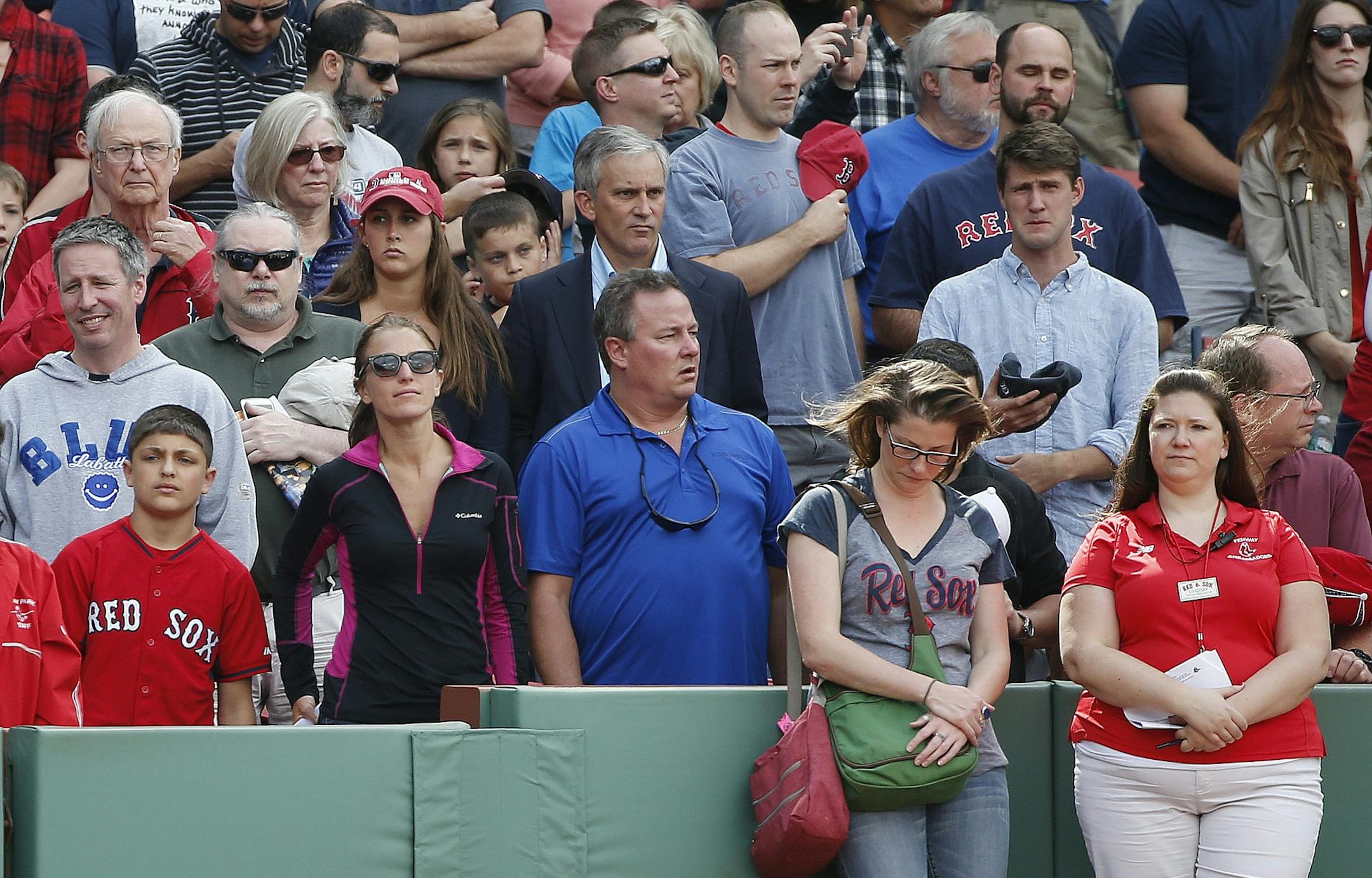 Fans observe a moment of silence before a baseball game between the Boston Red Sox and the Oakland Athletics, at Fenway Park in Boston, Saturday, June 6, 2015, in the area of the stands where a woman was hit and seriously injured by a broken bat during Friday's game. (AP Photo/Michael Dwyer) ORG XMIT: MAMD105