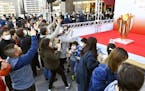 People gathered to take a look at Olympic flame on display north of Tokyo as calls grew for the games to be postponed.