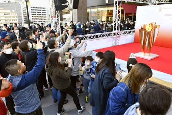 People gathered to take a look at Olympic flame on display north of Tokyo as calls grew for the games to be postponed.