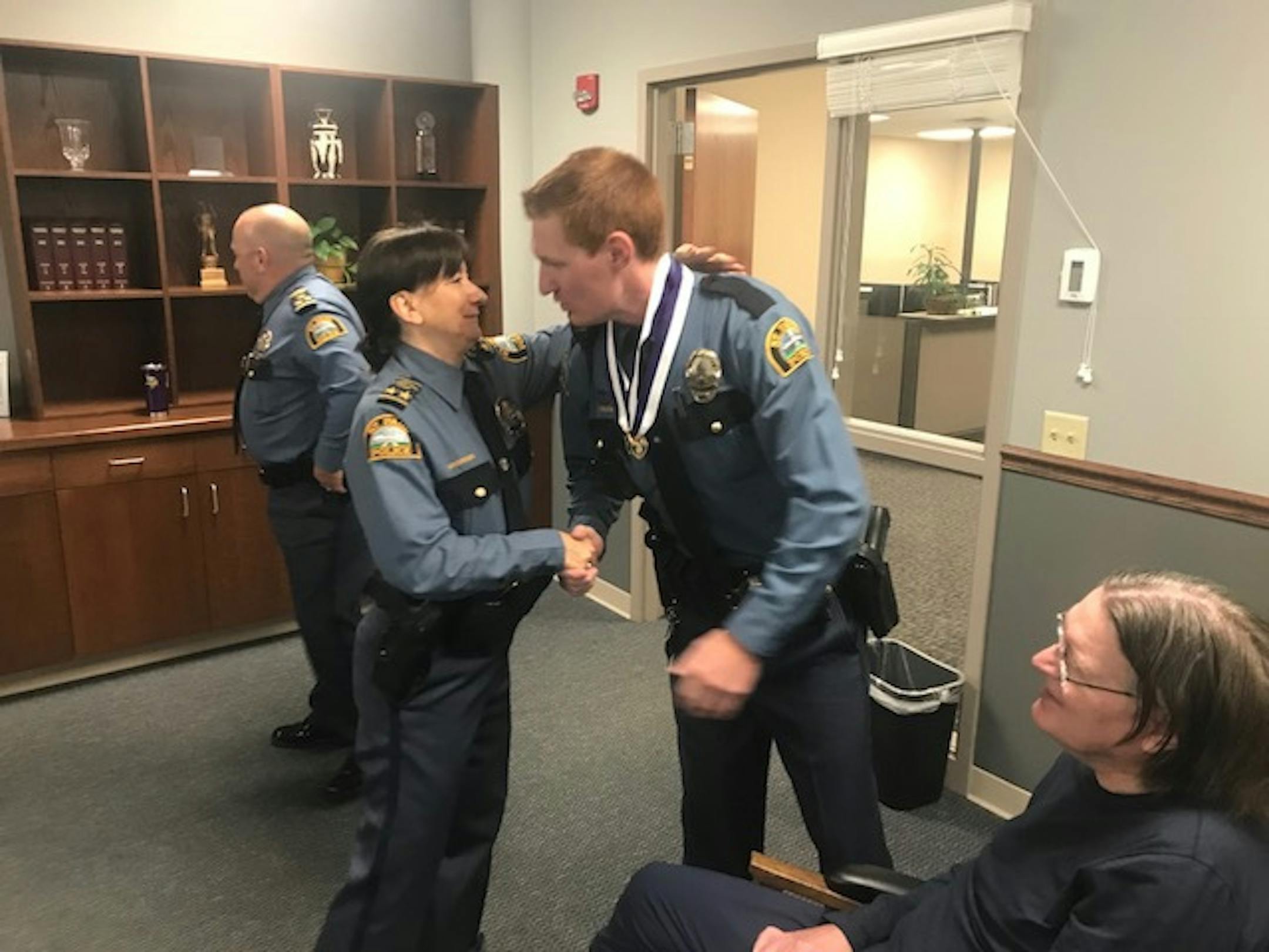 Assistant Chief Kathy Wuorinen congratulates Officer Alexander Graham, right, for earning two Lifesaving Awards on Wednesday, Aug. 29, 2018.