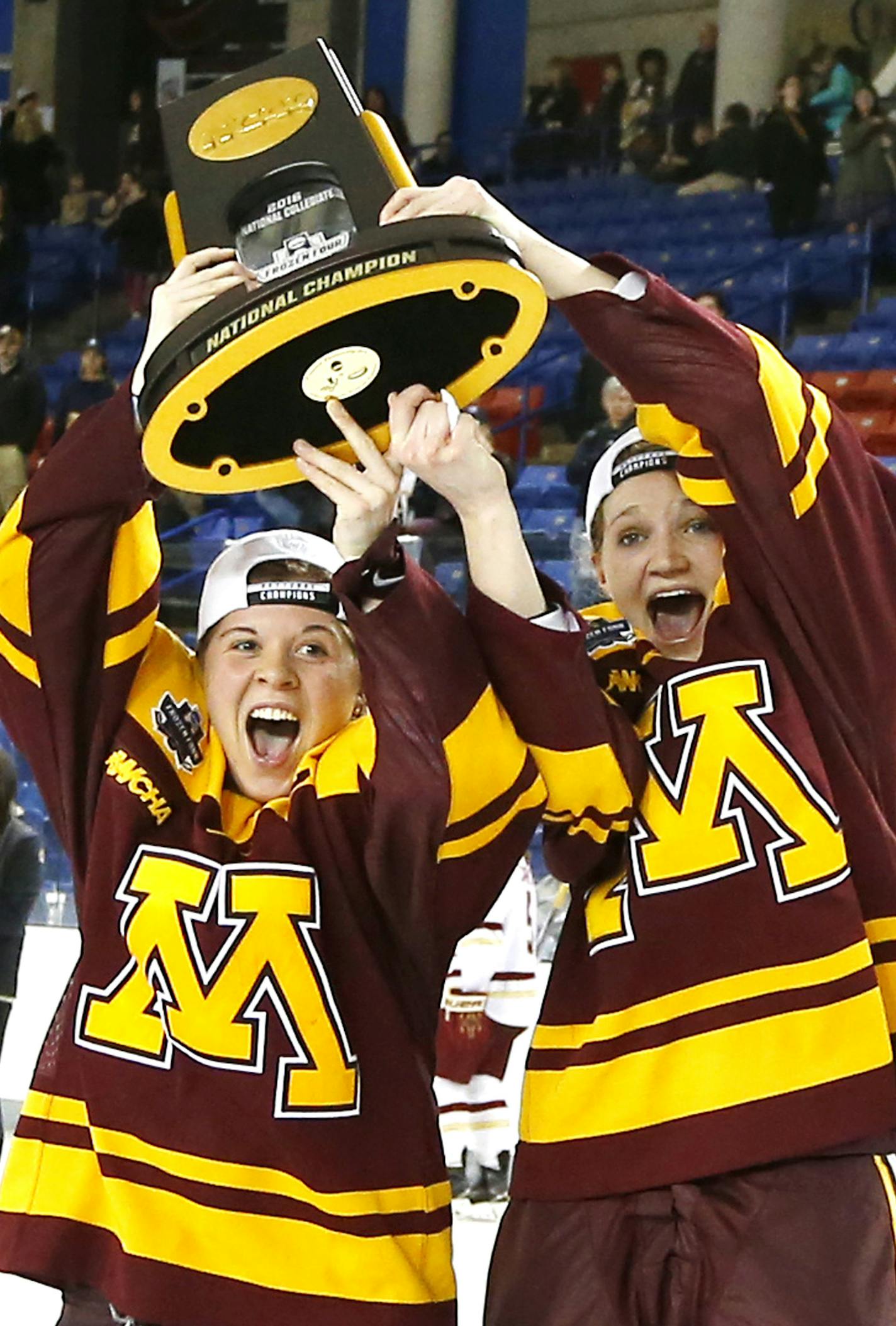 Minnesota captains Hannah Brandt, left, and Lee Stecklein receivee the trophy after defeating Boston College 3-1 in the women's Frozen Four championship college hockey game in Durham, N.H. Sunday, March 20, 2016. (AP Photo/Winslow Townson)