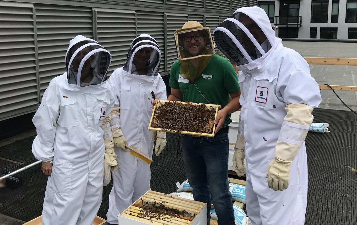 professional bee keeper Ben Grout (in center) with Kraus-Anderson employees Tonya Kostick, Amber Emly, and Mike Smoczyk. (Provided photo)