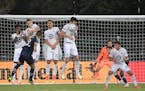 Minnesota United defender Jose Aja, center, gets hit in the face by the ball on a penalty kick by Sporting KC forward Alan Pulido (9) during Sunday's 