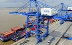 In this July 18, 2019, photo, shipping containers are loaded onto a cargo ship at a port in Nantong in eastern China's Jiangsu province. President Don