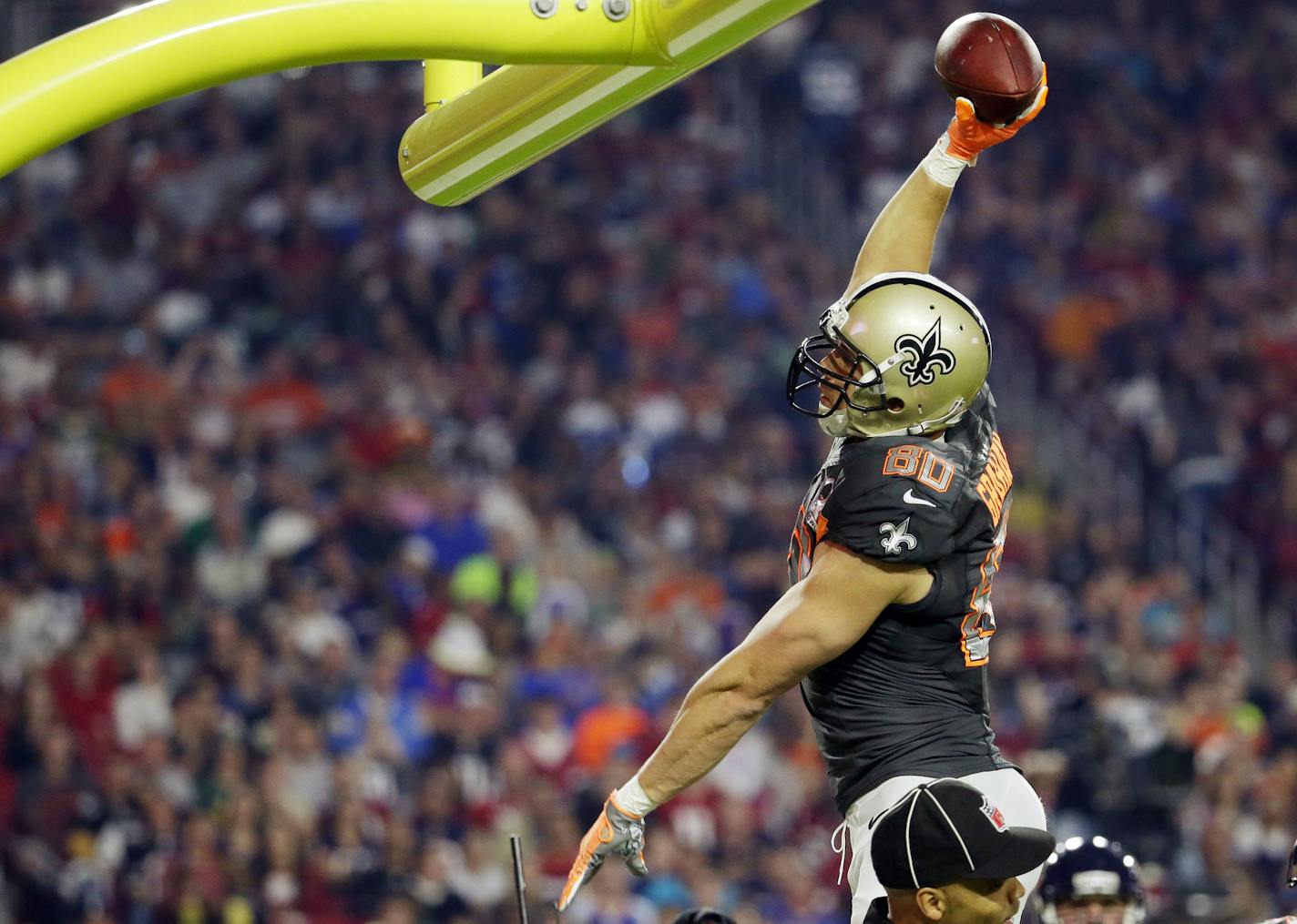 New Orleans Saints' Jimmy Graham leaps to throw the ball over the goal post after scoring a touchdown during the first half of the NFL Football Pro Bowl Sunday, Jan. 25, 2015, in Glendale, Ariz. (AP Photo/Charlie Riedel)