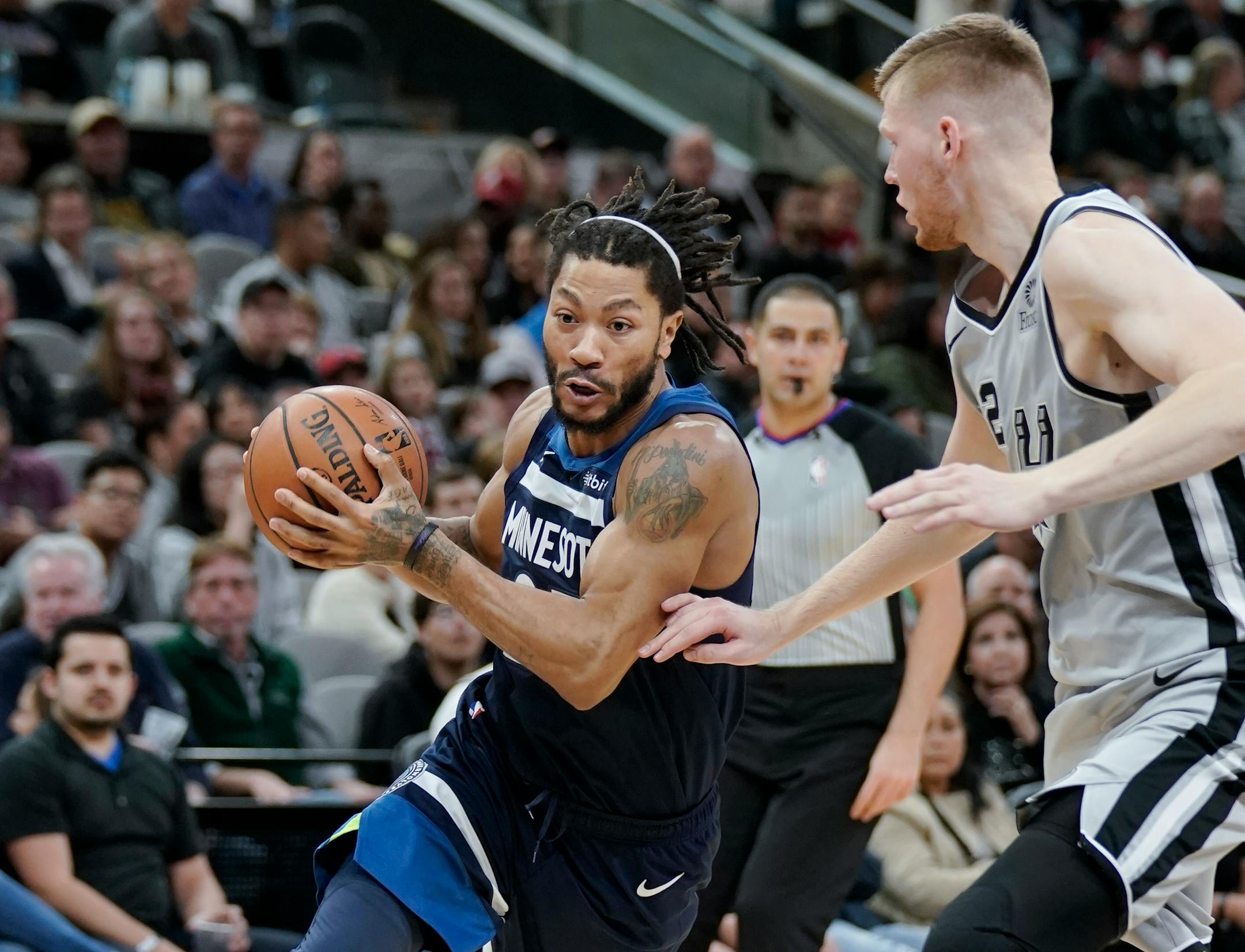 Minnesota Timberwolves' Derrick Rose, left, drives around San Antonio Spurs' Davis Bertans during the first half of an NBA basketball game, Friday, Dec. 21, 2018, in San Antonio. (AP Photo/Darren Abate)