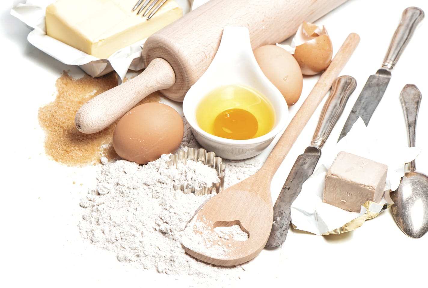 Baking ingredients eggs, flour, sugar, butter, yeast. Food background with antique cutlery, istock photo