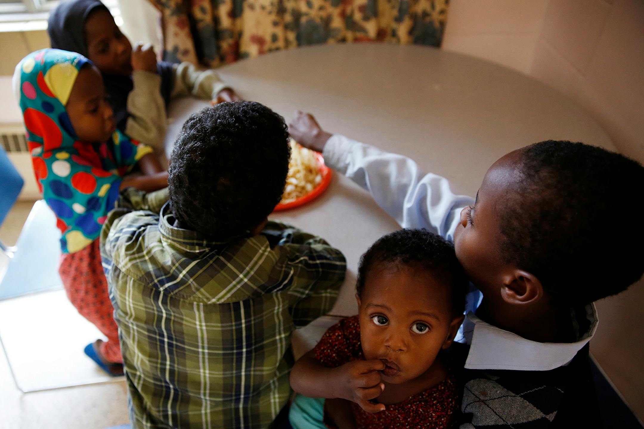 Recent Somali immigrant Ikra Shukri, 1, enjoys an afternoon snack of pasta with goat meat at home with her siblings at Mary's Place transitional apartments in downtown Minneapolis. ] LEILA NAVIDI leila.navidi@startribune.com / BACKGROUND INFORMATION: Tuesday, October 28, 2014. Minnesota has seen a marked uptick in new Somali refugee arrivals recently. The number of Somalis arriving directly from Africa has more than tripled in four years. But community leaders say there's also been an increase i