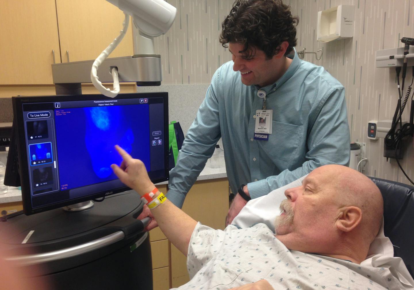 Image 895 Caption: Dr. Tom Masters, an ER doctor trained in hyperbaric medicine, and Paul Vetsch, 61, of Burnsville, examine an image showing weak blood flow in Vetsch&#xed;s foot since a severe scald sent him to Hennepin County Medical Center for treatment a week earlier. The areas in white, shown on the Luna fluorescence angiography screen, depict weak circulation in Vetsch&#xed;s foot. Credit: Joe Carlson