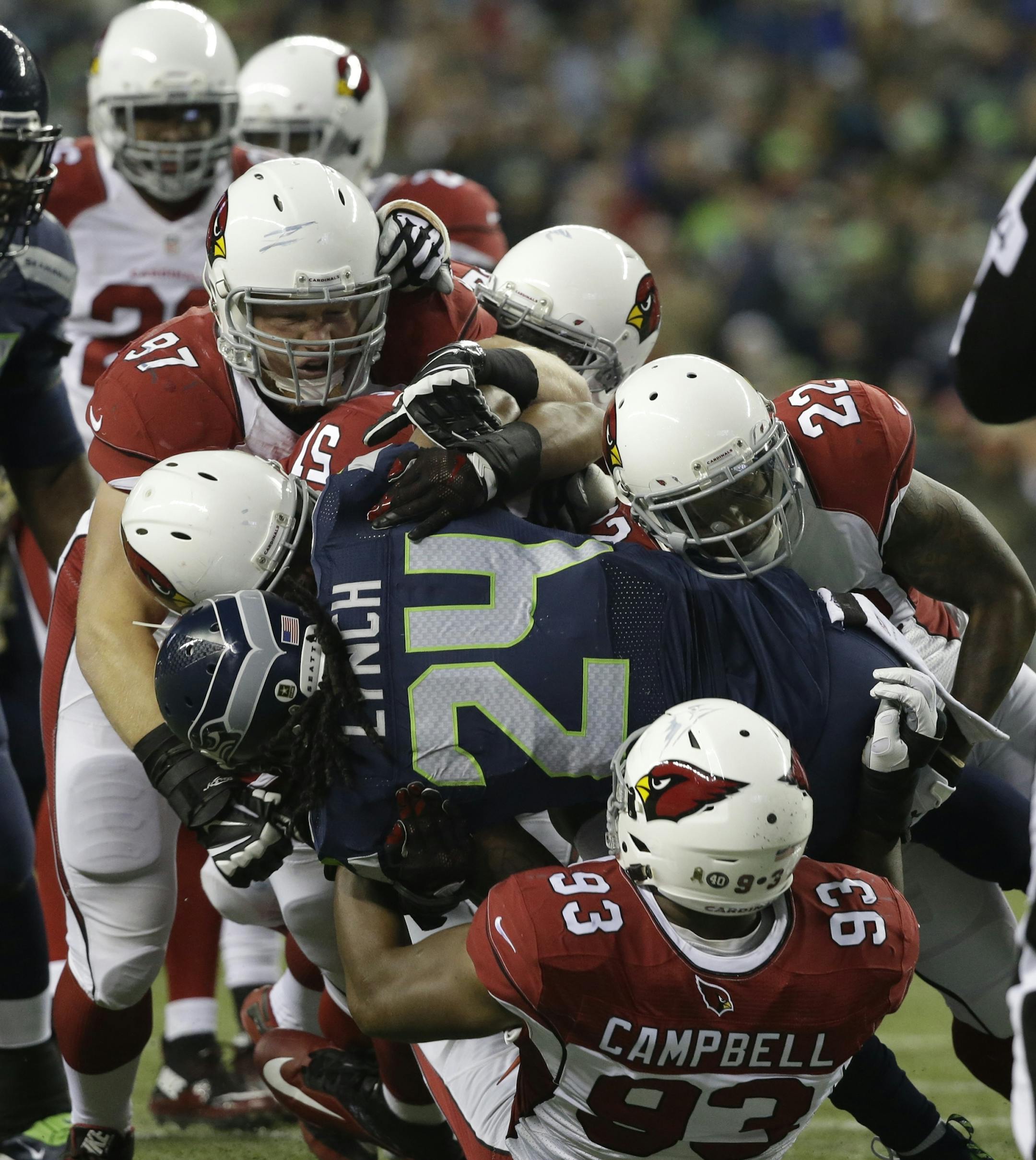FILE - In this Nov. 15, 2015, file photo, Seattle Seahawks running back Marshawn Lynch (24) is tackled by a host of Arizona Cardinals players in the first half of an NFL football game in Seattle. On a Sunday night seven weeks ago, the Cardinals pulled off a 39-32 victory over the Seahawks. They havenít lost since. Now both teams are firmly in the playoffs, with seeding all thatís at stake when they meet in their regular-season finale on Sunday. (AP Photo/Elaine Thompson, File)