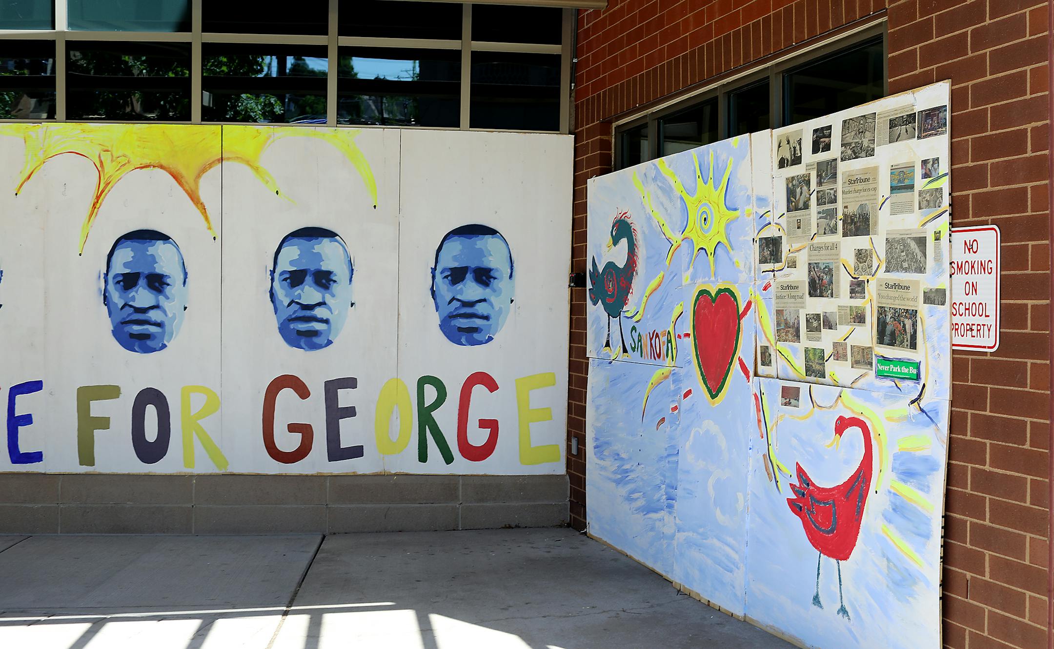 A blue-tinted portrait of George Floyd and front pages of the Star Tribune appear on two murals covering the windows of Gordon Parks High School at 1212 University Ave. W. in St. Paul.