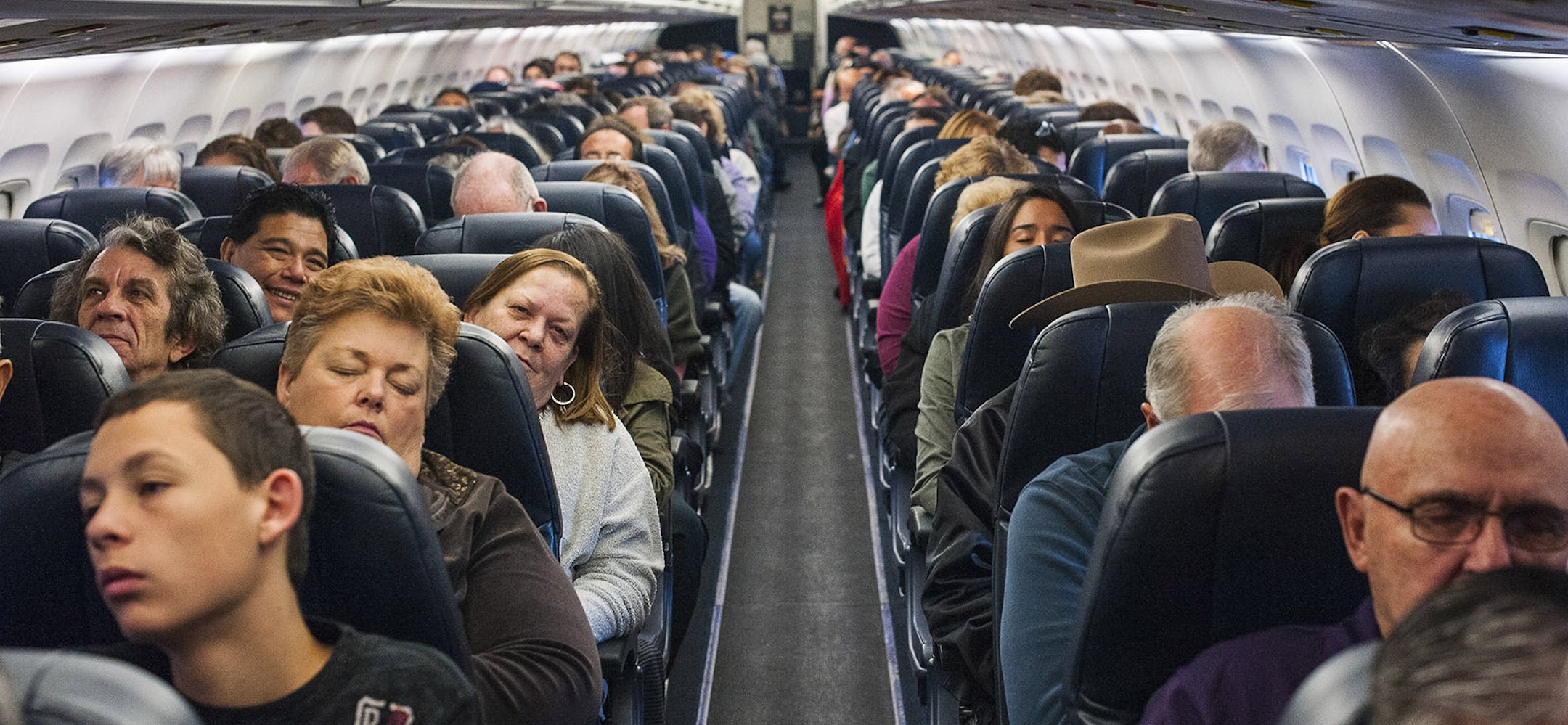 Passengers aboard an Allegiant Airlines flight en route from Las Vegas to Colorado Springs, Colo., Dec. 19, 2013. To gain a little more space between seats in the continuing push to add passengers, airlines like Allegiant, which uses seats that do not recline, are turning to a new generation of seats that use lighter materials and less padding. (Joe Giron/The New York Times) ORG XMIT: MIN2013122315411997