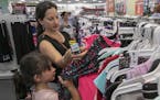 Paula Rosado, of Meriden, shops for clothes for daughter, Camila, 6, during tax-free week at Kohl's in Wallingford, Conn., Mon., Aug. 19, 2019. (Dave 