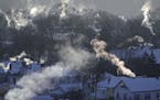 Smoke rises from the chimneys of homes in St. Paul's West 7th neighborhood Wednesday, Jan. 30, 2019, as furnaces tried to keep up with the record brea